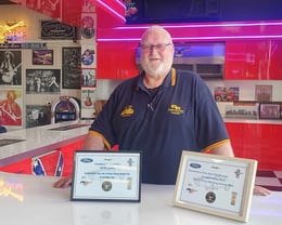 Nelson accepts a certificate for hosting the Mustang club at Ross Bros Museum